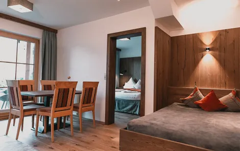 Spielberg Modern hotel suite with dining area, cozy bed, and view into separate bedroom